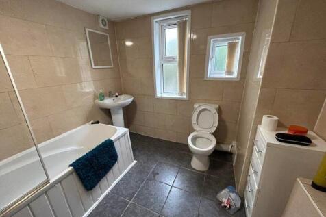A spacious and well-lit bathroom featuring a ba...