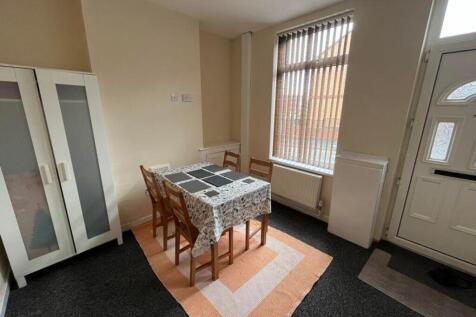 A cozy communal lounge with a dining table, ide...