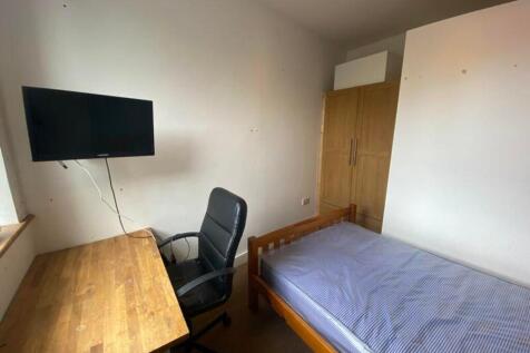 A tidy single bedroom with a desk and chair, id...