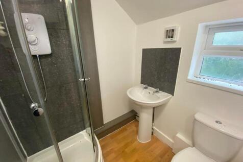 A modern bathroom featuring a shower, sink, and...