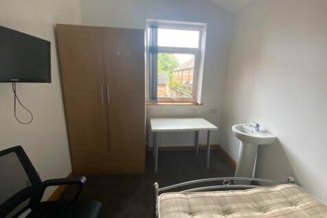 A bright and tidy double bedroom with a desk an...