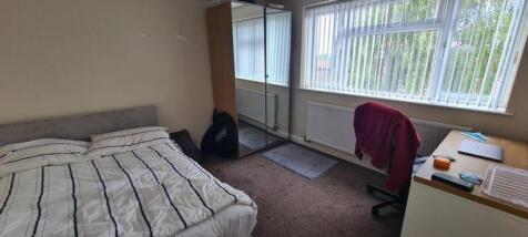 A spacious and well-lit double bedroom with amp...