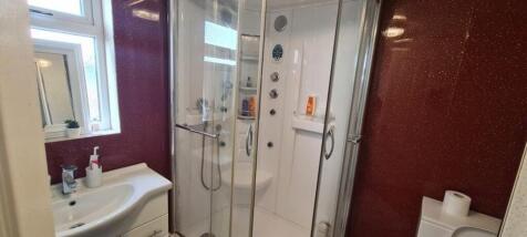 A modern bathroom featuring a spacious shower a...