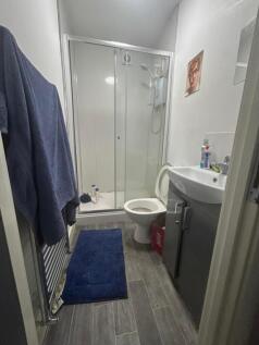 A modern bathroom featuring a spacious shower a...