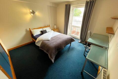 A spacious and inviting double bedroom with nat...