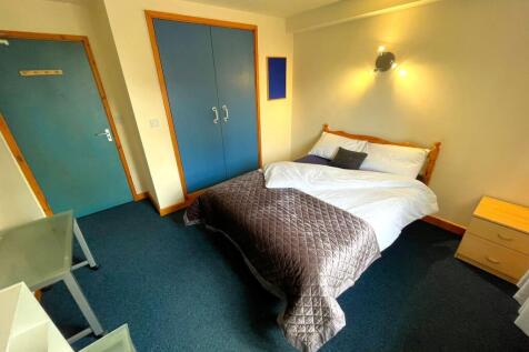 A cozy double bedroom featuring a large bed and...