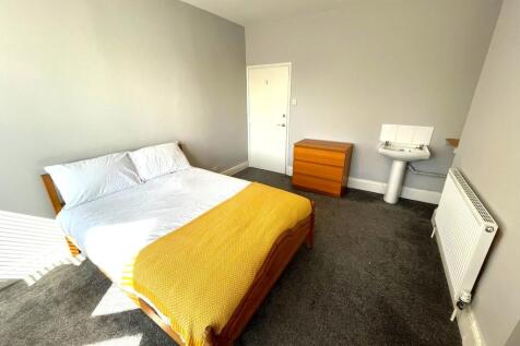 A spacious and bright double bedroom featuring ...