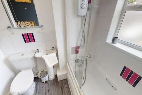 A tidy and modern bathroom featuring a shower a...
