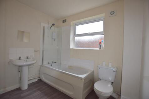 A modern and tidy bathroom featuring a bath and...