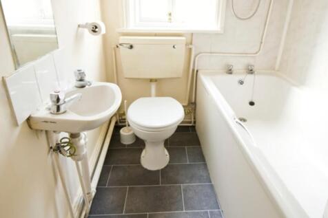 A clean and tidy bathroom featuring a bath and ...