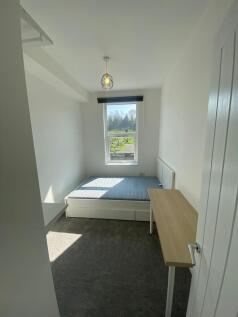 A bright and tidy single bedroom featuring a la...