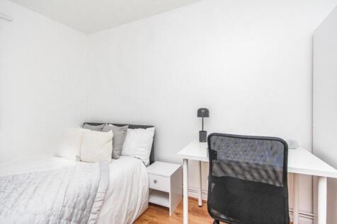 This charming double bedroom features a cozy be...