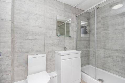 A modern bathroom featuring sleek grey tiles, a...
