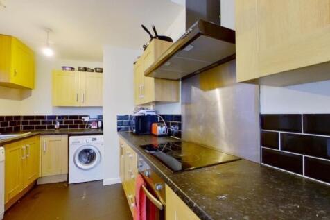 A modern and tidy kitchenette with ample storag...