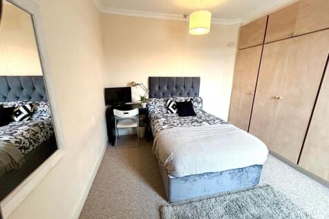 This cozy double bedroom features a comfortable...