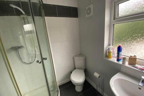 A modern bathroom featuring a shower, toilet, a...