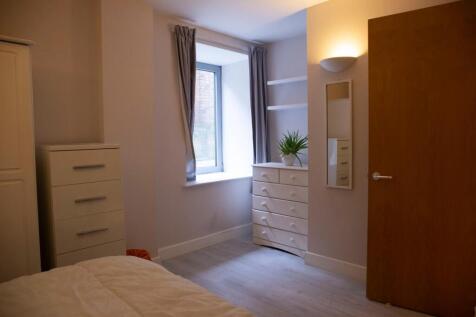 This cozy double bedroom features a large windo...