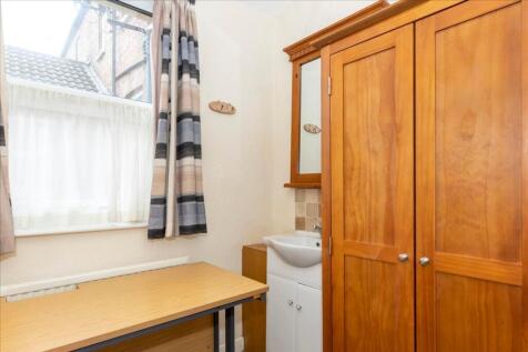 This cozy double bedroom features a warm wooden...