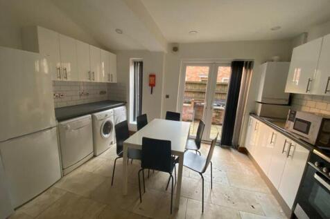 A spacious and modern kitchen equipped with ess...