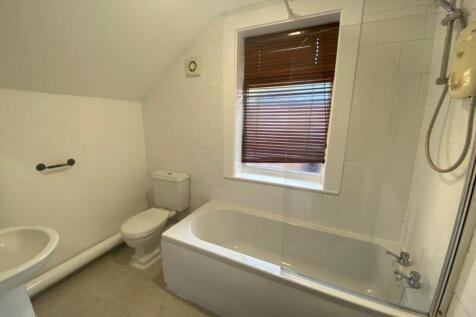 A spacious and bright bathroom featuring a comf...