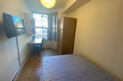 A bright and spacious double bedroom with a des...