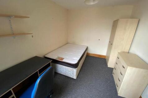 A spacious double bedroom with essential furnis...
