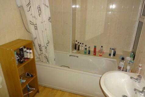 A functional bathroom featuring a bathtub and a...