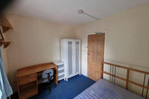 A spacious and tidy double bedroom featuring a ...