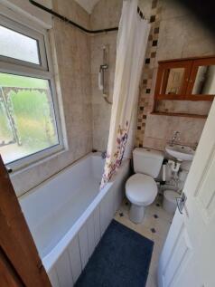 A well-maintained bathroom with natural light a...