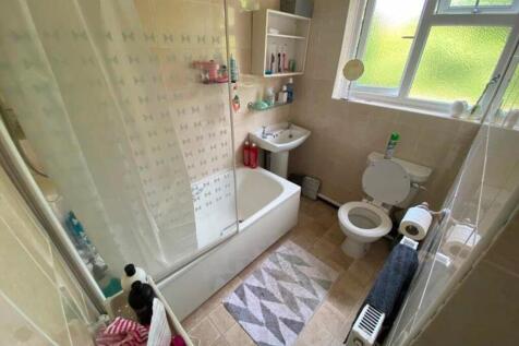 A spacious and clean bathroom featuring a bath ...