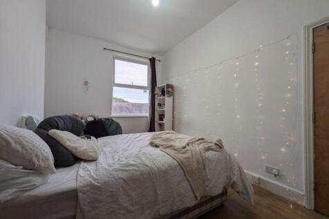 A cozy and well-lit double bedroom featuring ch...