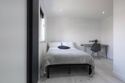 A bright and modern double bedroom with a comfo...