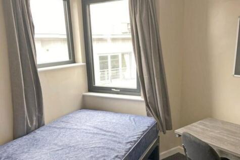 A bright and tidy single bedroom featuring larg...