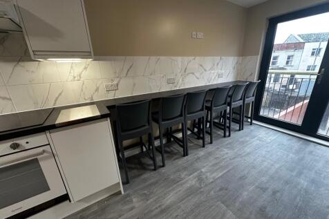 A modern kitchen featuring sleek cabinetry, sty...