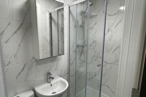 Modern bathroom featuring a sleek glass shower,...