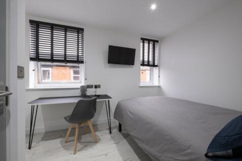 A bright and tidy double bedroom featuring mode...