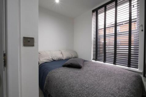 A bright and tidy double bedroom featuring mode...