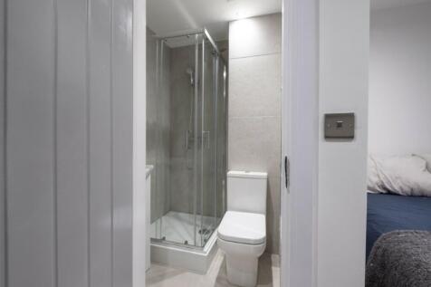 A modern and tidy bathroom featuring a shower a...