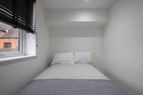 A cozy single bedroom with a minimalist design,...