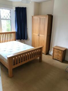 Spacious double bedroom featuring a cozy wooden...
