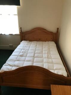 Cozy double bedroom featuring a charming wooden...