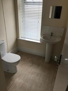 A cozy bathroom featuring a modern sink and toi...