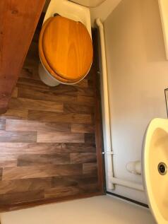 A tidy and functional single toilet area featur...