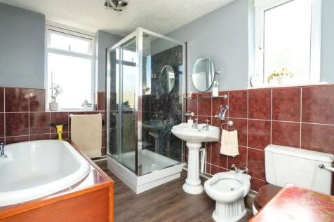 This spacious bathroom suite features a large b...