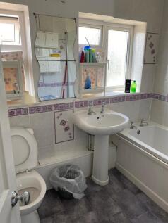 A clean and spacious bathroom featuring a batht...