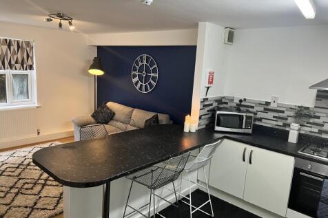 A modern kitchen featuring stylish bar stools a...