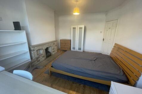 A spacious double bedroom featuring a comfortab...