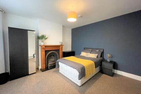 This spacious double bedroom features a cozy am...