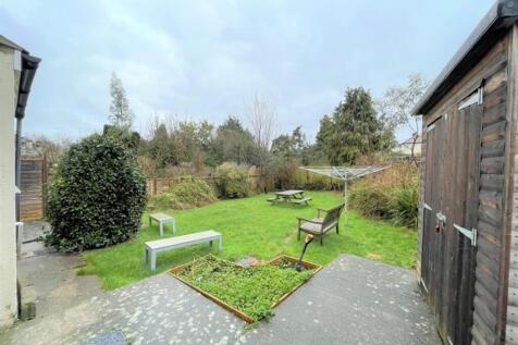 A charming garden space featuring green grass, ...