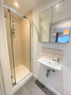 A modern bathroom featuring a stylish shower, s...